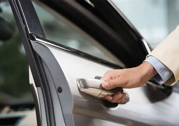 A person opening a car door using a key fob.